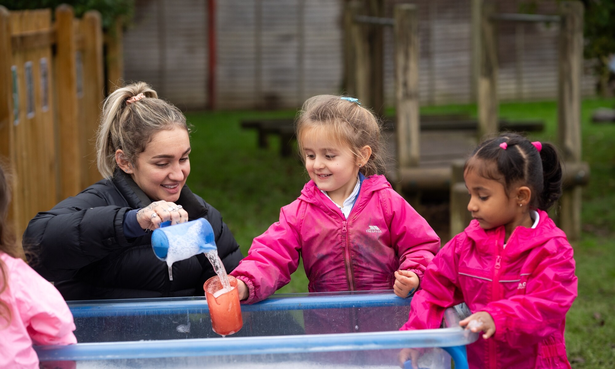 Warren Dell Primary School teacher helping a pupil in outdoor learning
