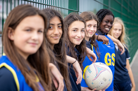 Girls stood in a row dressed in netball bibs