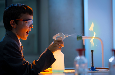 Boy spraying a bunsen flame with a spray bottle