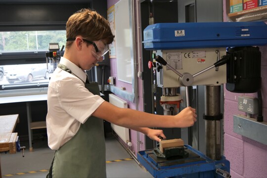 Corby Technical School - Student using a pillar drill in DT