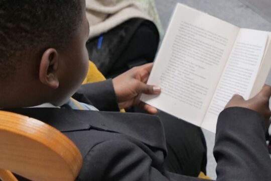 Corby technical school student reading a book in a rocking chair