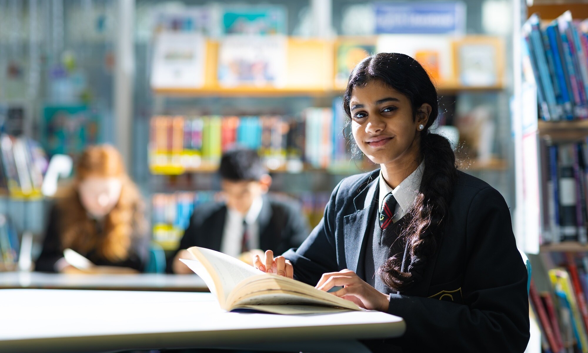 Cove school student smiling with book