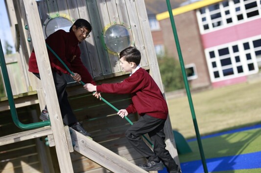 Alton Park Pupils outside playing on climbing frame