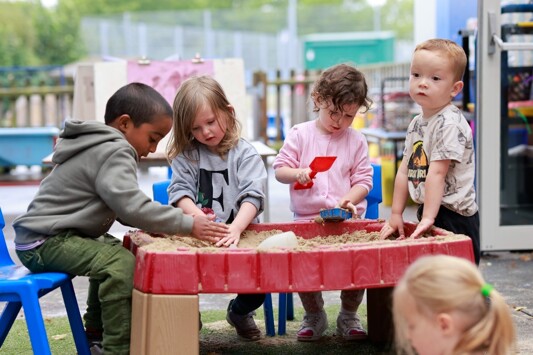 Monkwick infant and nursery school group of children exploring outdoor play