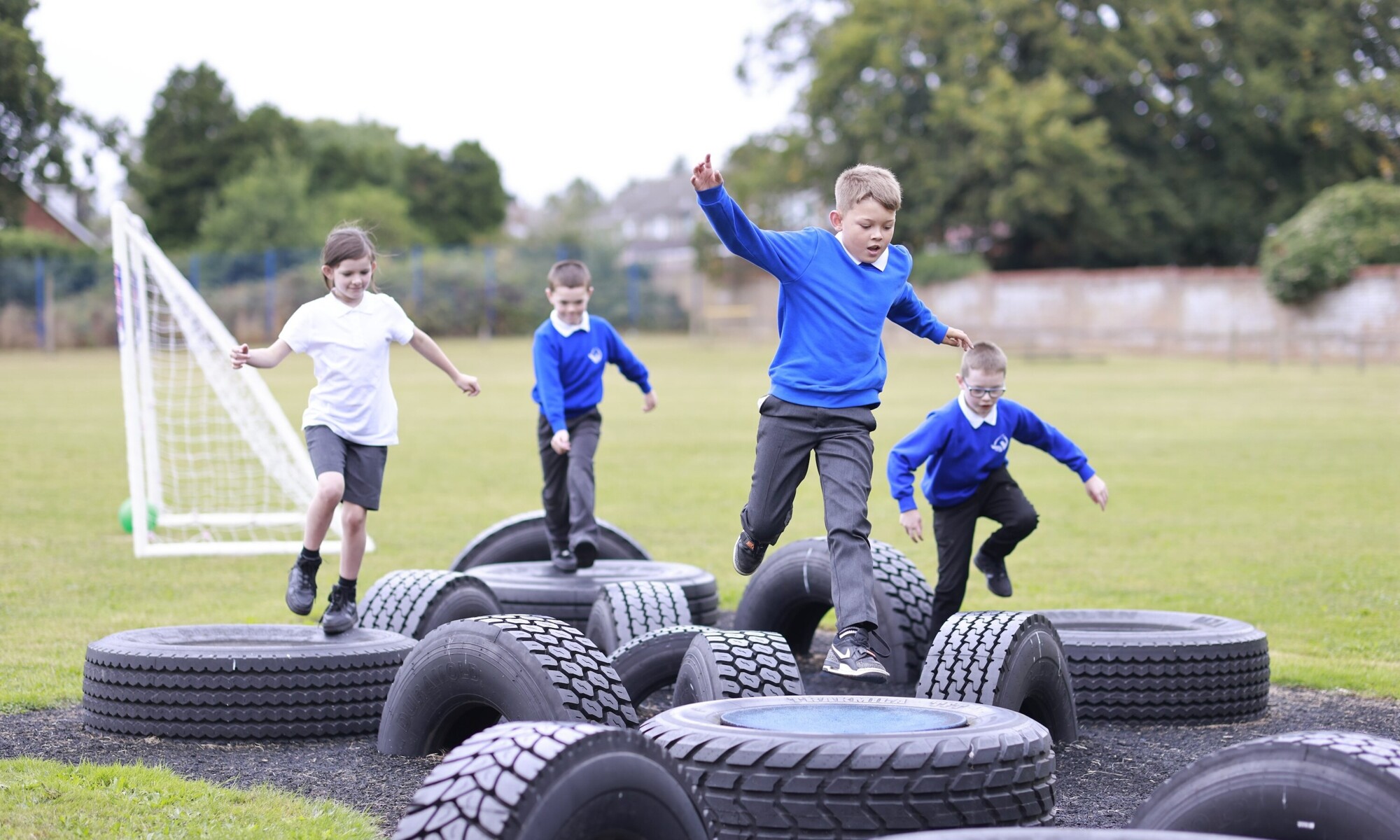 Students jumping on car tyres during play time